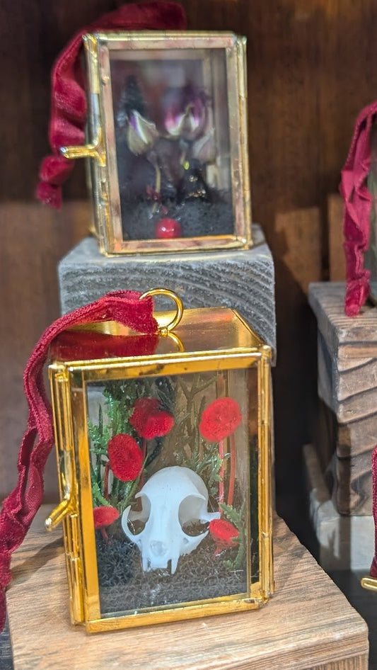 Decorative boxes with gold frames and red ribbons on a wooden surface.